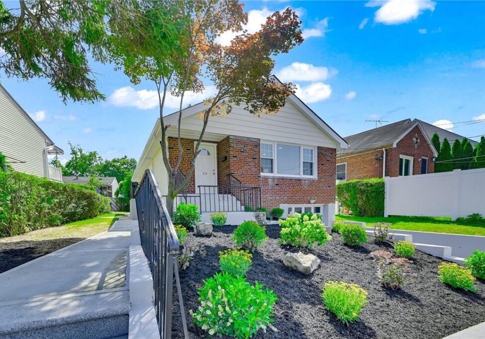 Charming brick house with a well-kept garden and clear blue sky.