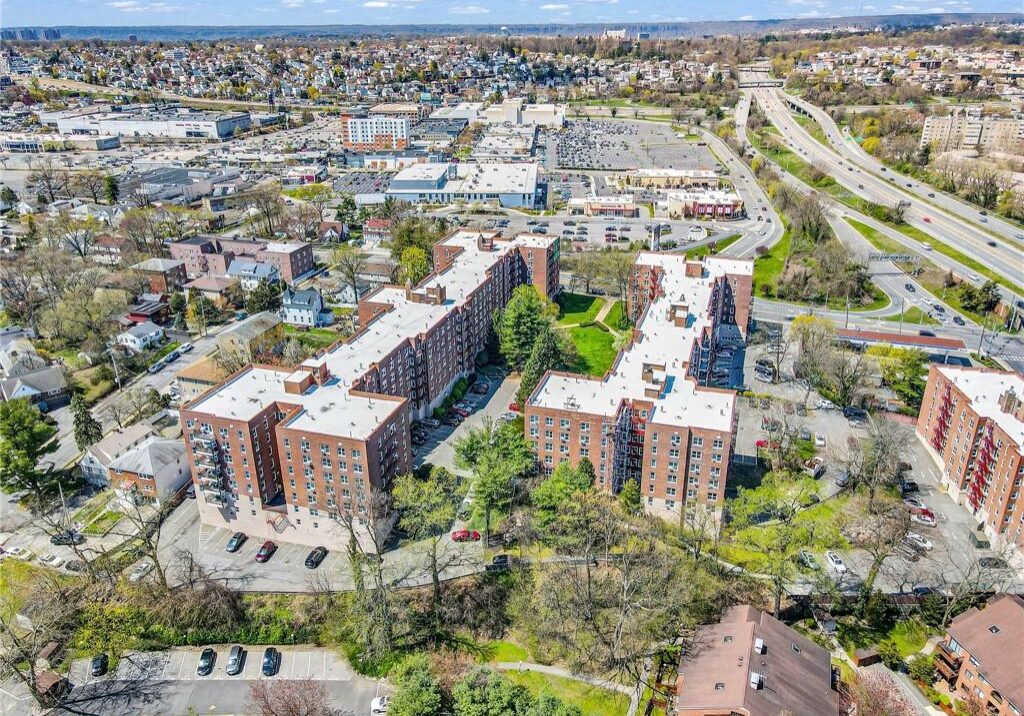 Aerial view of a residential complex in an urban area with nearby highway.