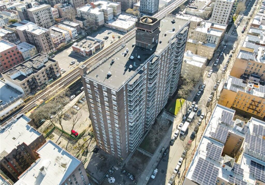Tall residential building in a dense urban area under clear skies.