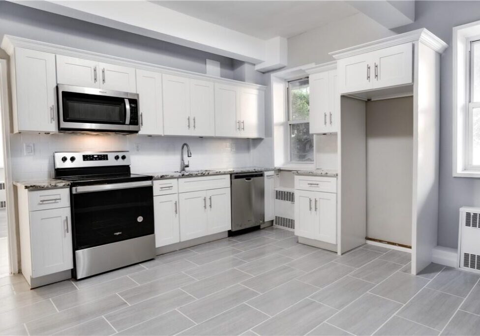 Modern kitchen with white cabinets and stainless steel appliances.