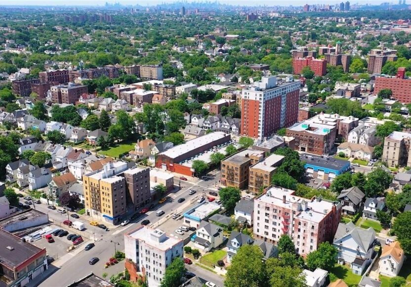 Aerial view of a city with buildings and greenery.