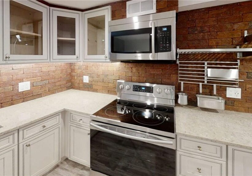 Modern kitchen with stainless steel appliances and white cabinetry.