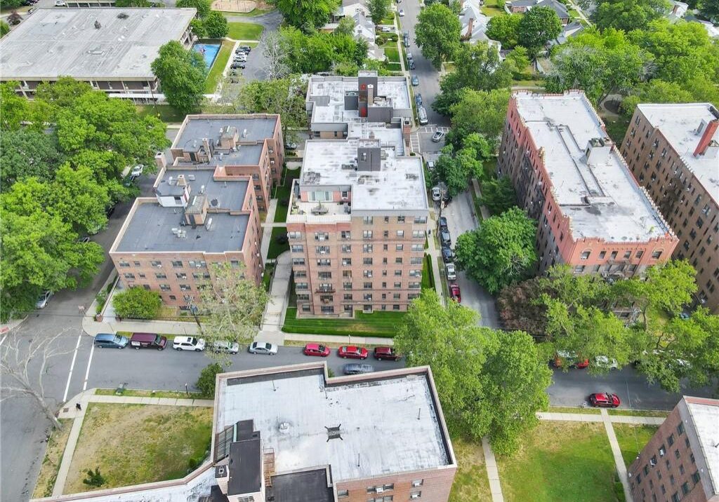 Aerial view of residential buildings surrounded by trees and greenery.