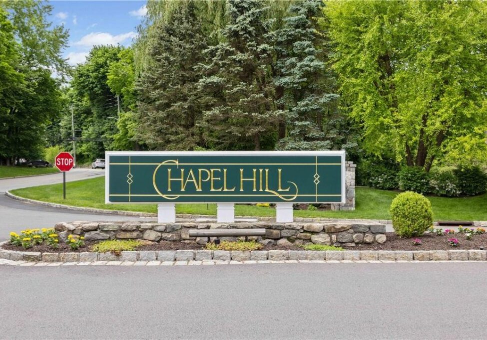 Entrance sign for Chapel Hill surrounded by greenery.