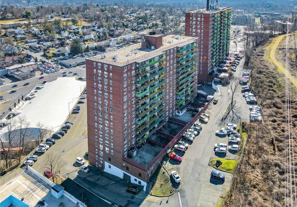 Aerial view of a tall residential building in an urban area.