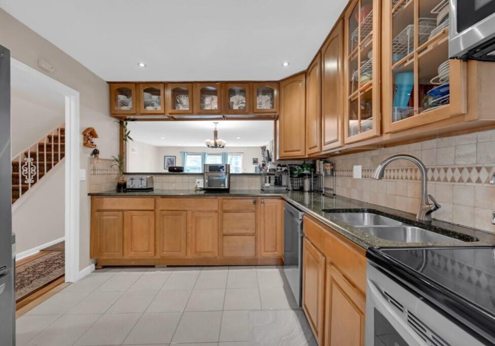 Spacious kitchen with wooden cabinets and black countertops.