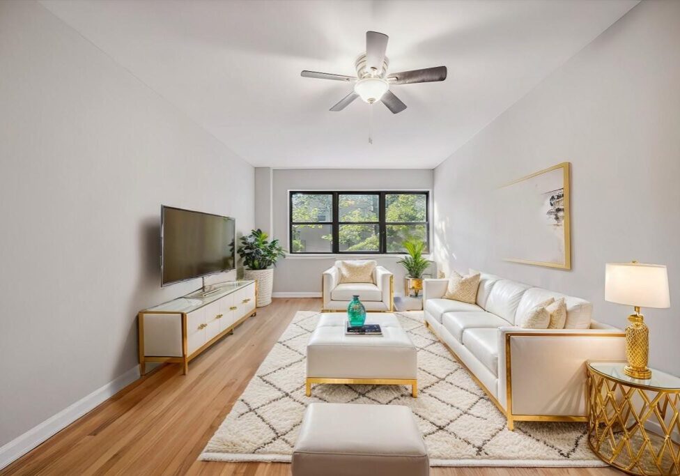 Modern bright living room with white furniture and wood flooring.