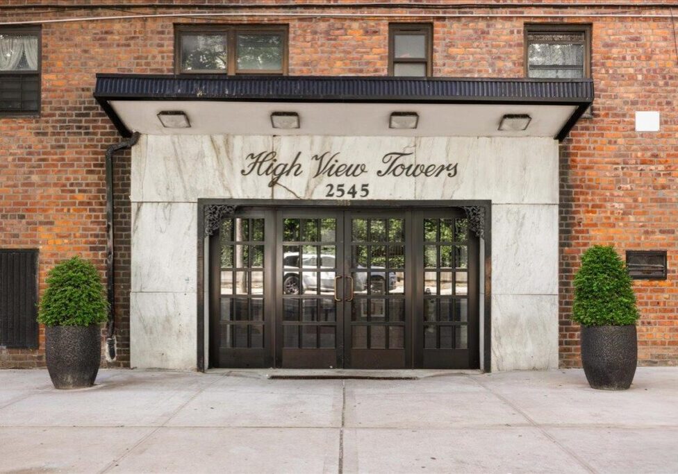 Facade of Ralph Lauren store with glass doors and white stone frame.