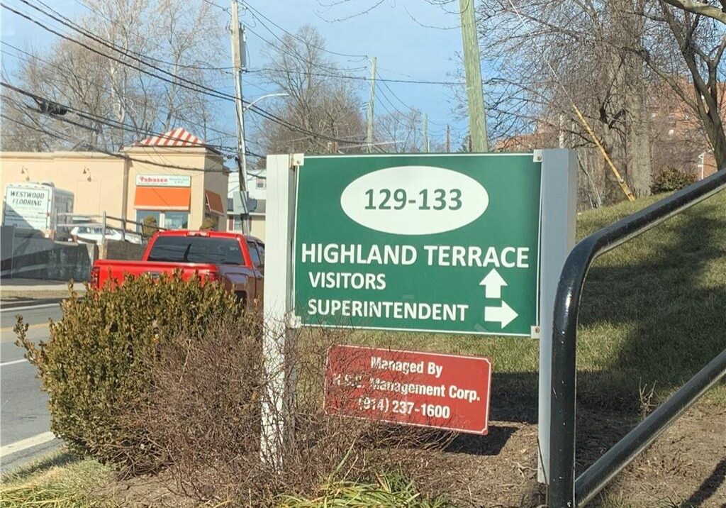 Sign directing visitors and superintendent to Highland Terrace with fire truck in background.
