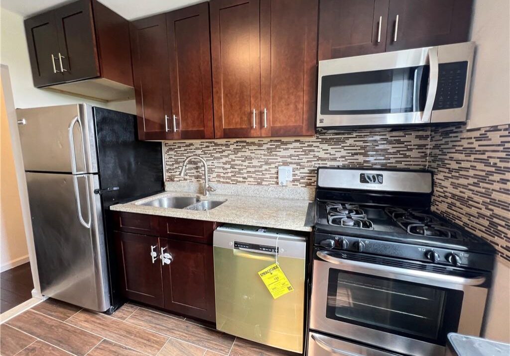 Modern kitchen with stainless steel appliances and wooden cabinets.