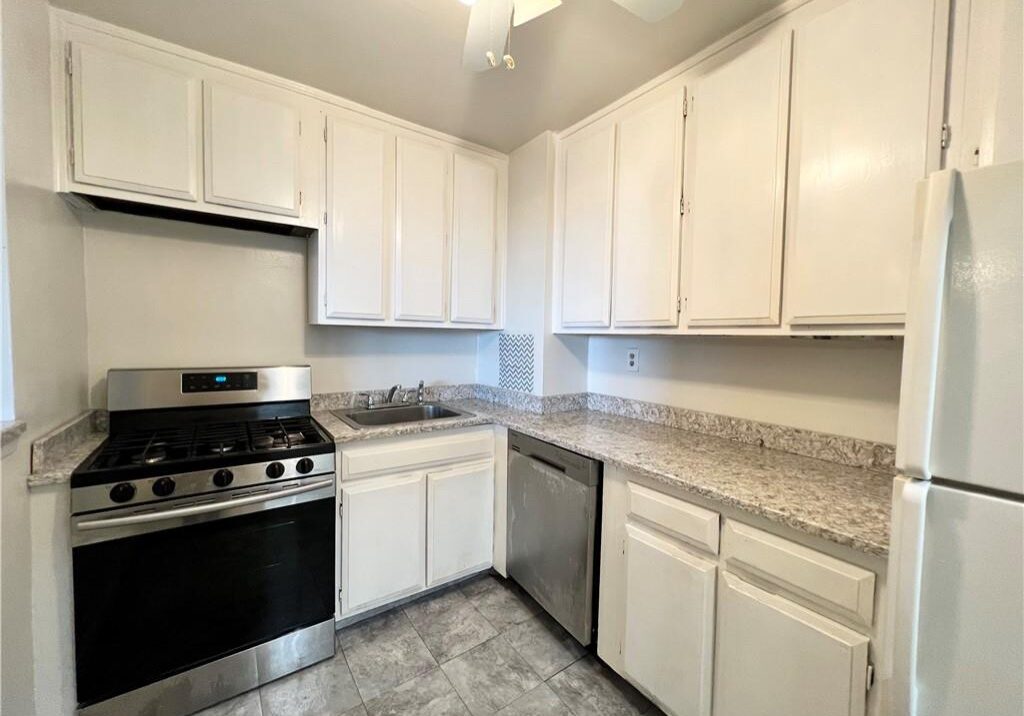 Clean kitchen with white cabinets and stainless steel appliances.
