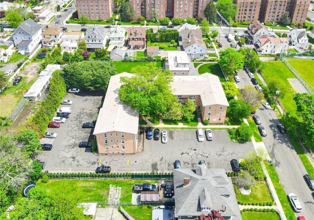 Aerial view of a residential neighborhood with brick buildings and parked cars.