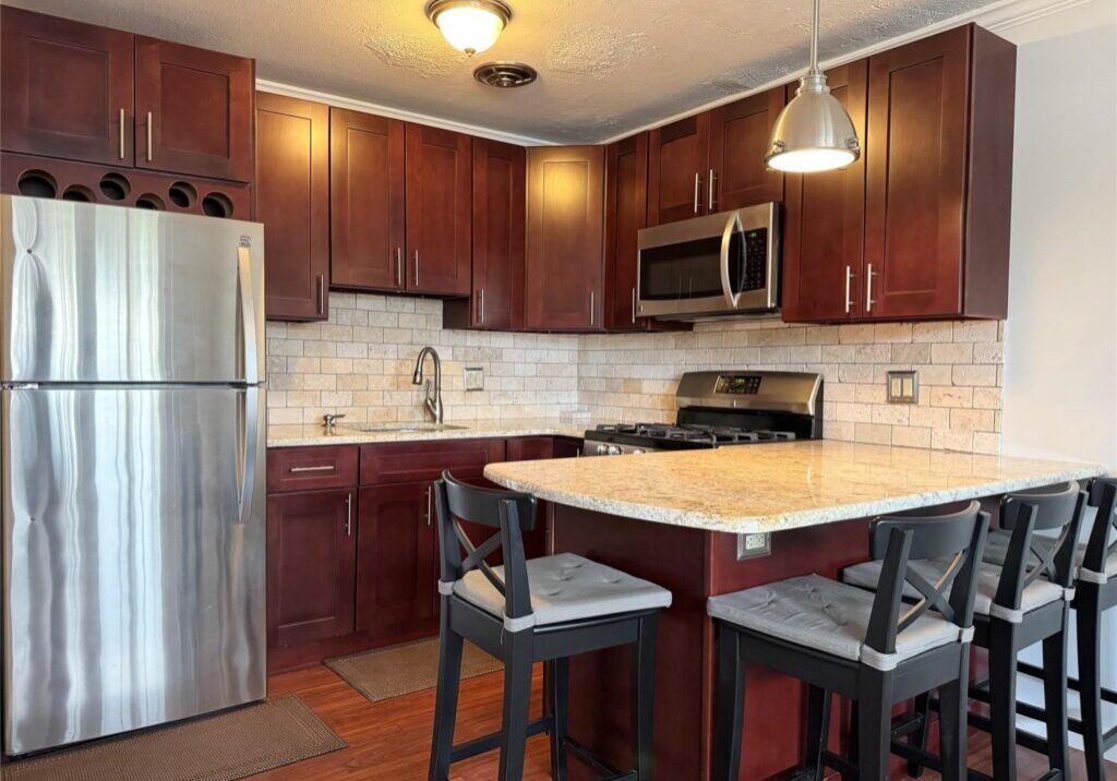 Modern kitchen with wooden cabinets and island seating.