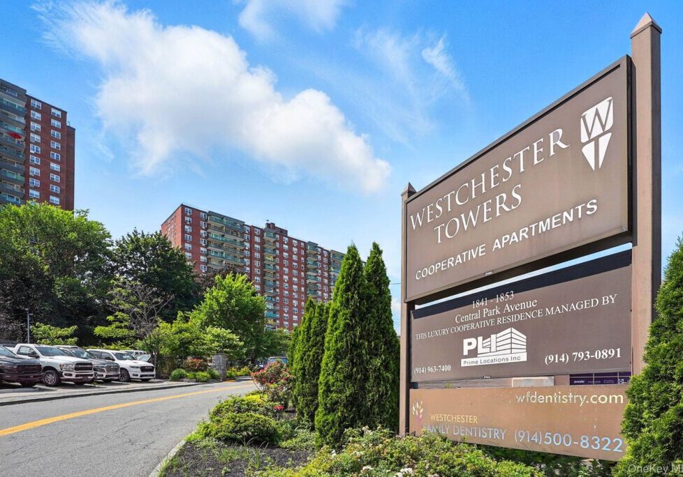 Preshyster Towers entrance with clear sky and greenery.