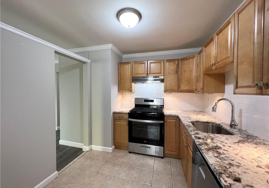 Modern kitchen with wooden cabinets and granite countertops.